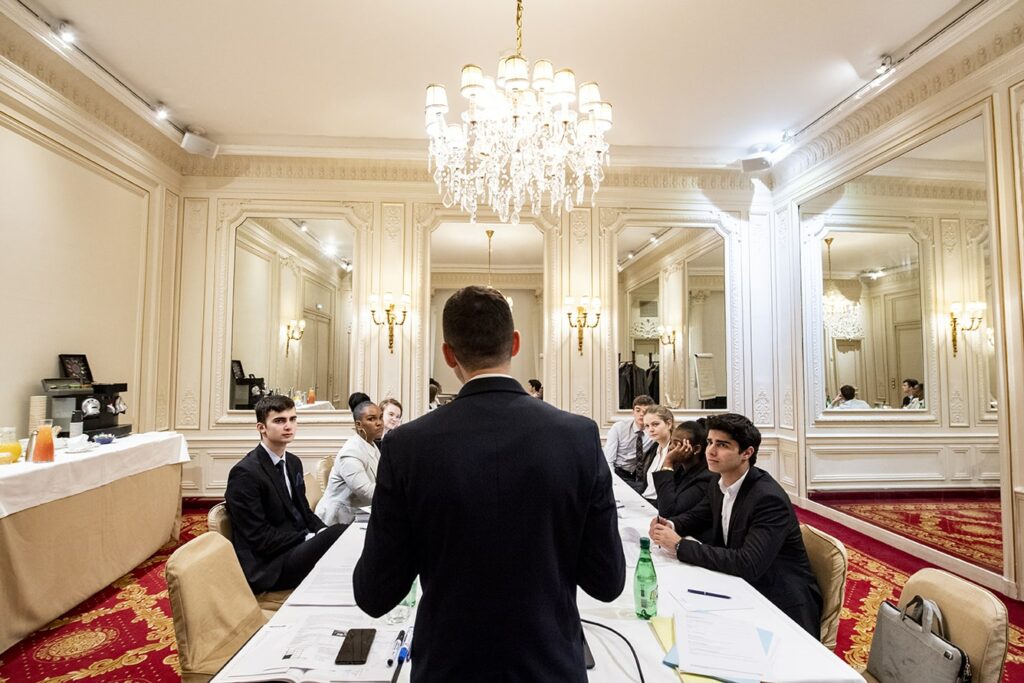 Des étudiants assis autour d'une grande table - Luxury Hotelschool